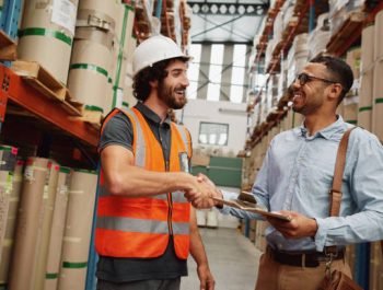 Happy handsome customer in formal clothing shaking hand of storage manager with clipboard after discussing contract
